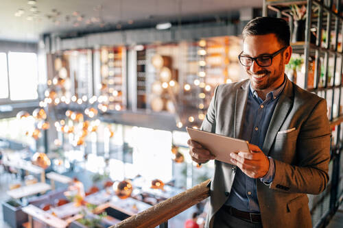 Happy young business man using a digital tablet at office